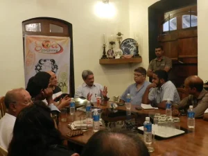 A big discussion is taking place at the Conference Room of the Gonsalves Mansion. People of all walks of life are questioning Manohar as to the Future of Goa!