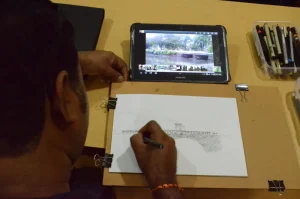 Artiste Vijay Bhandare refereing to a picture he took of the existing bridge