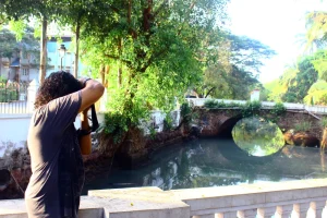 Beautiful picture of Prasad Pankar taking a photograph of the Portuguese time bridge near Hotel Vivanta!