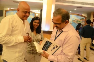 Dr. Ashwani Kumar presents a book to Armando Gonsalves. Ashwani Kumar presents a book to Armando Gonsalves